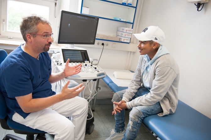 Dr. Benjamin Berlemann, Senior Physician in the Department of Pediatrics and Adolescent Medicine at HELIOS Hospital in Duisburg, Germany and patient Anthony Bauer in a discussion during a checkup 
